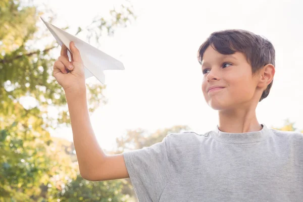 Sonriente chico con avión de papel en el parque — Foto de Stock