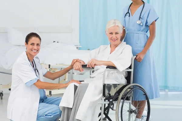 Doctors and patient in wheelchair — Stock Photo, Image