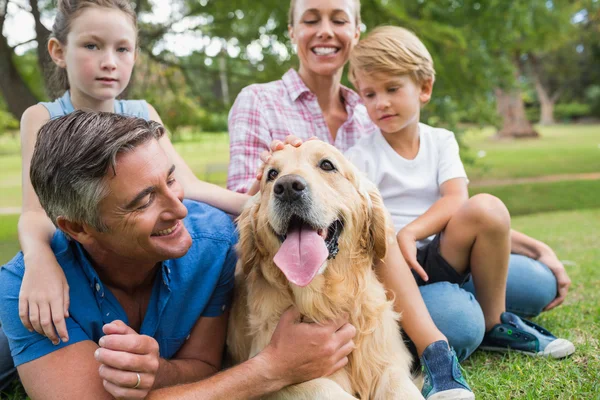 Happy family in the park with their dog — Stock Photo, Image