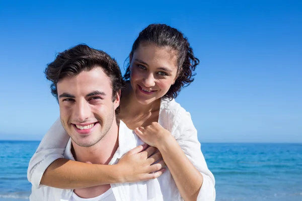 Schöner Mann gibt seiner Freundin Huckepack zurück — Stockfoto