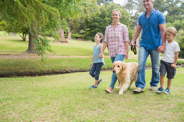 Família feliz no parque com seu cão — Fotografia de Stock