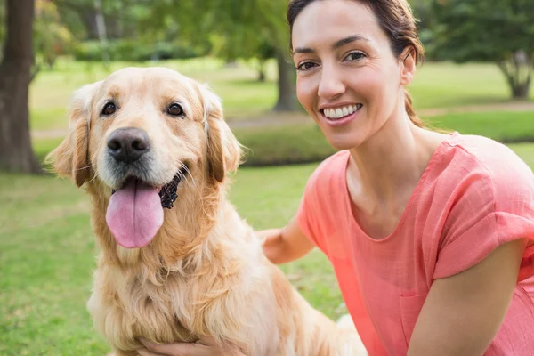 Mooie brunette op zoek naar camera met haar hond — Stockfoto