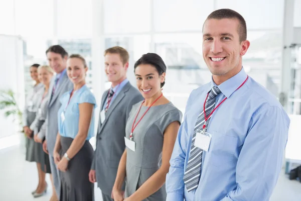 Business team standing in row and smiling at camera — Stock Photo, Image