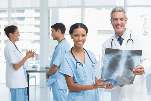 Male and female doctors examining x-ray — Stock Photo, Image