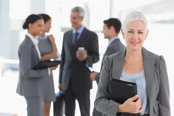 Businesswoman with colleagues behind in office — Stock Photo, Image