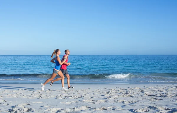 Feliz pareja corriendo juntos al lado del agua —  Fotos de Stock