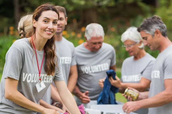 Feliz voluntario mirando la caja de donaciones — Foto de Stock