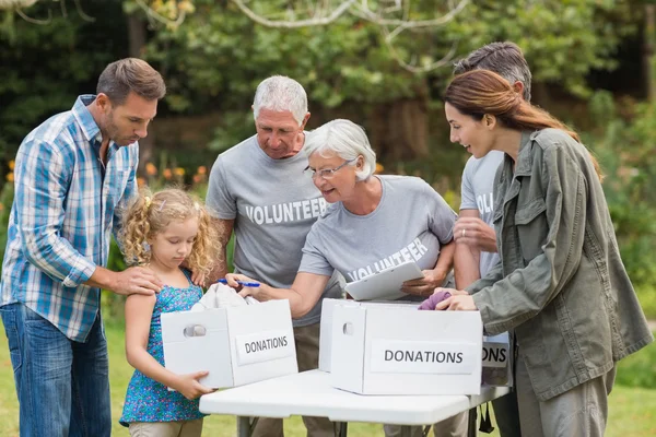 Felices voluntarios de la familia separando las donaciones — Foto de Stock