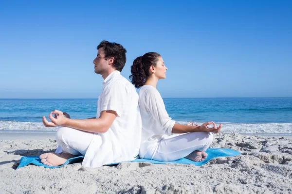 Happy couple doing yoga beside the water — Stock Photo, Image