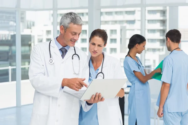 Male and female doctors working on reports — Stock Photo, Image