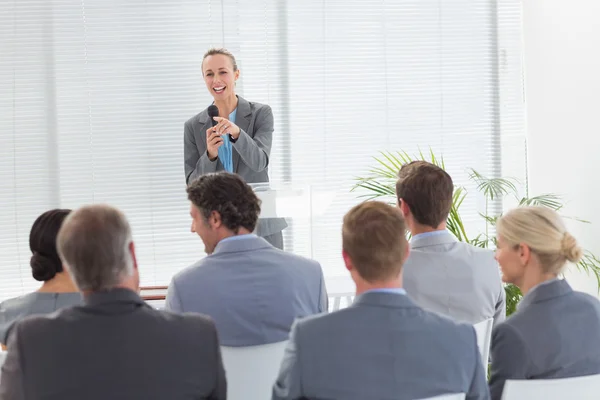 Mooie zakenvrouw in microfoon te praten tijdens de conferentie — Stockfoto