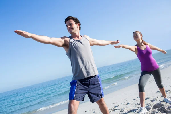 Pareja feliz haciendo yoga al lado del agua —  Fotos de Stock