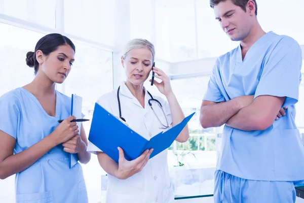 Equipo de médicos mirando la carpeta —  Fotos de Stock