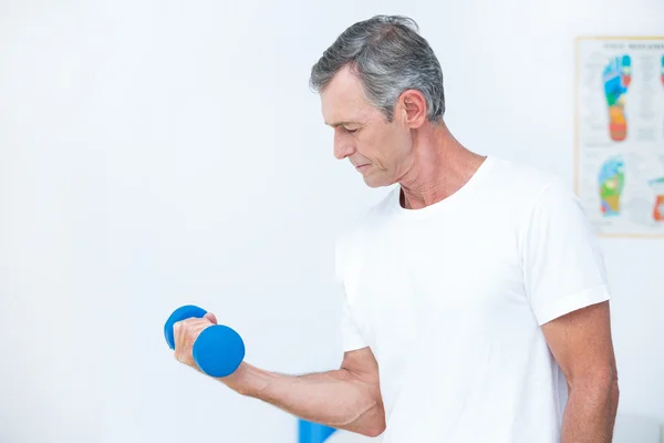 Patient lifting dumbbell — Stock Photo, Image