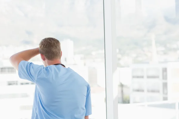 Male doctor looking through windows — Stock Photo, Image