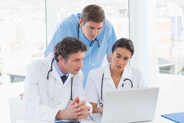 Team of doctors working on laptop computer — Stock Photo, Image
