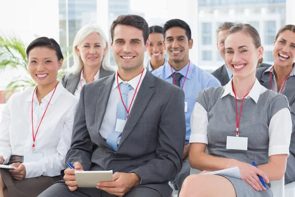 Lächelnde Geschäftsleute blicken während der Besprechung in die Kamera — Stockfoto
