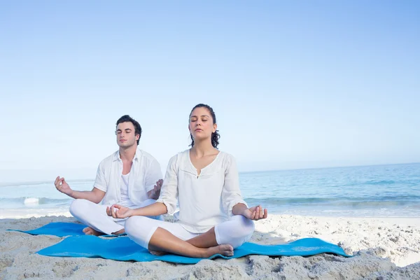 Glückliches Paar beim Yoga neben dem Wasser — Stockfoto