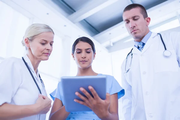 Médicos olhando juntos para tablet — Fotografia de Stock