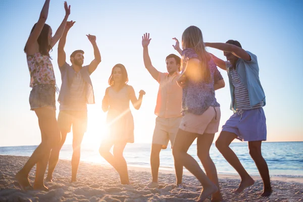 Amigos felizes dançando na areia — Fotografia de Stock