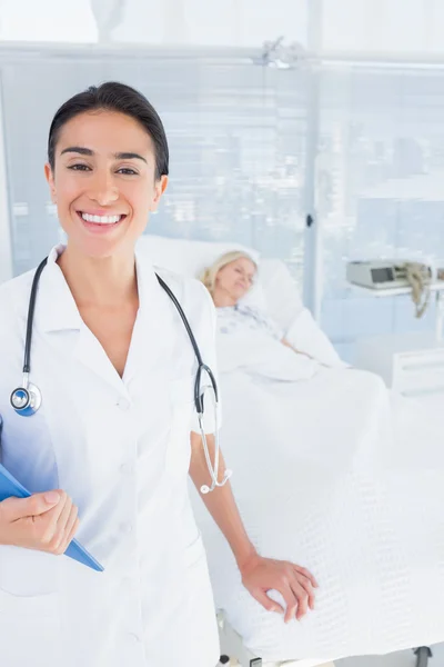 Uśmiechnięty doktor patrząc na kamery w pokoju pacjentów — Zdjęcie stockowe