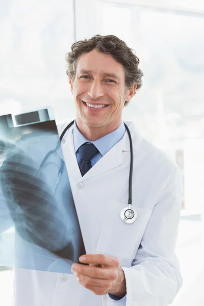 Happy doctor holding X-ray and smiling at camera — Stock Photo, Image