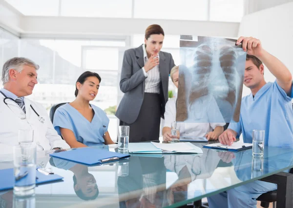 Team av läkare och affärskvinna undersöka xray — Stockfoto