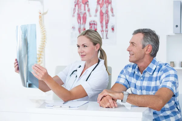 Doctor mostrando rayos X a su paciente — Foto de Stock