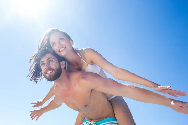 Schöner Mann gibt seiner Freundin Huckepack zurück — Stockfoto