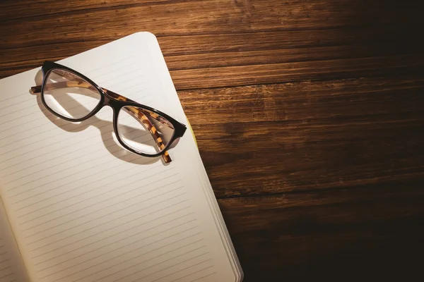 Empty notepad with reading glasses — Stock Photo, Image