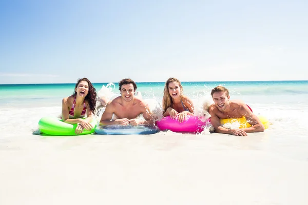 Des amis heureux allongés sur un matelas gonflable au-dessus de l'eau — Photo