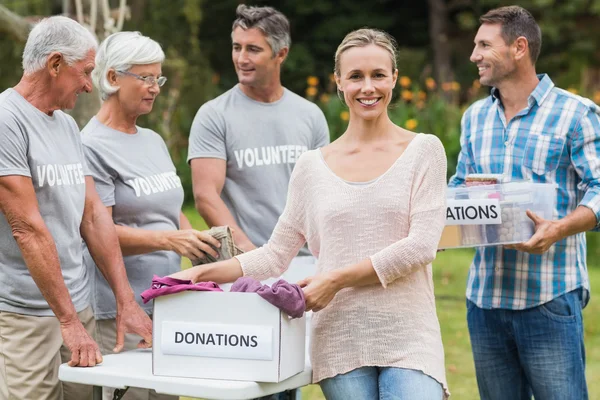 Felices voluntarios de la familia separando las donaciones —  Fotos de Stock