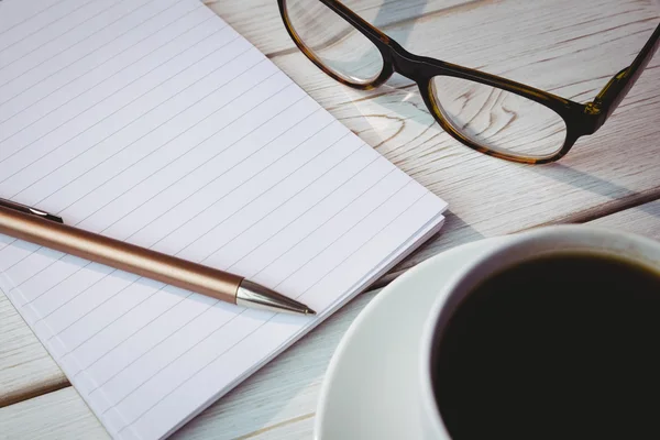 Bloco de notas vazio com óculos de leitura e xícara de café — Fotografia de Stock