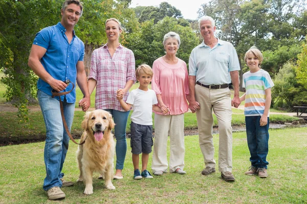 Familia feliz sonriendo a la cámara con su perro — Foto de Stock
