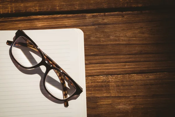 Bloco de notas vazio com óculos de leitura — Fotografia de Stock