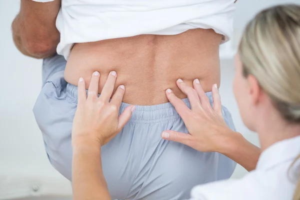 Arzt untersucht Patientin zurück — Stockfoto