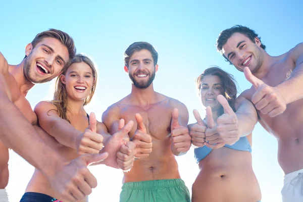 Amigos felizes sorrindo para a câmera mostrando polegares para cima — Fotografia de Stock