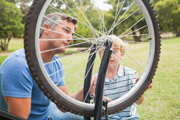 Far och hans son fastställande en cykel — Stockfoto