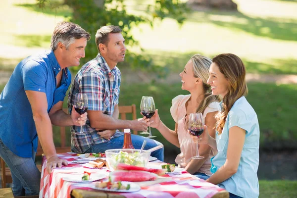 Glückliche Freunde stoßen im Park an — Stockfoto