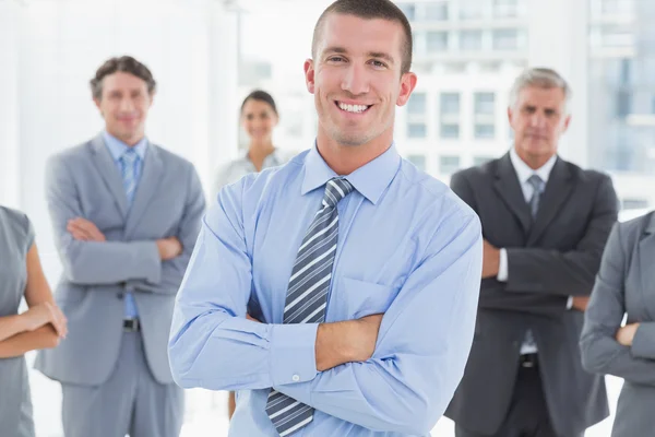 Smiling business team in piedi con le braccia incrociate — Foto Stock