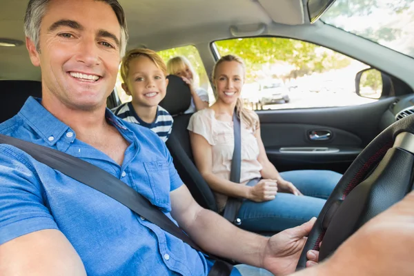 Joyeux famille souriant à la caméra dans la voiture — Photo