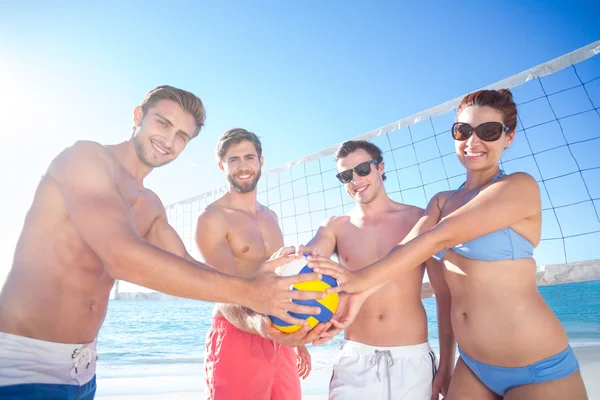 Група друзів тримає волейбол і посміхається на камеру — стокове фото