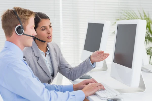 Geschäftsteam arbeitet am Computer und trägt Headsets — Stockfoto