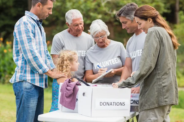 Felices voluntarios de la familia separando las donaciones — Foto de Stock