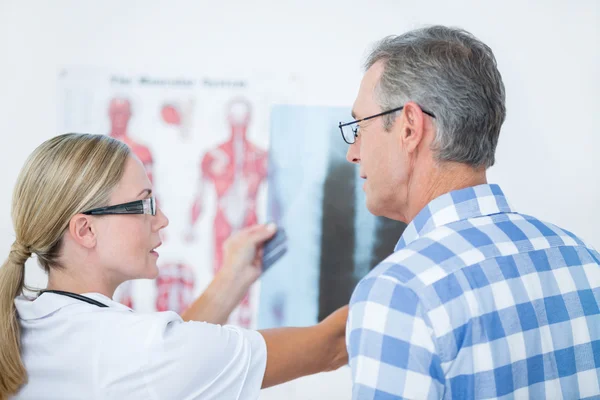 Läkare visar röntgen till hennes patient — Stockfoto