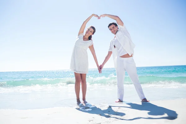 Happy couple forming heart shape with their hands — Stock Photo, Image