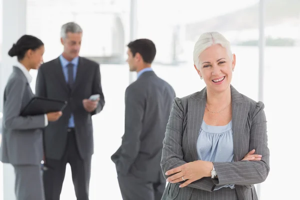 Empresaria con colegas detrás en la oficina —  Fotos de Stock