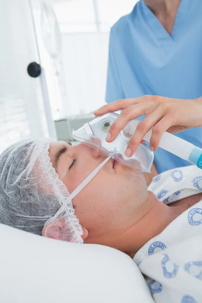 Doctor holding patients oxygen mask — Stock Photo, Image