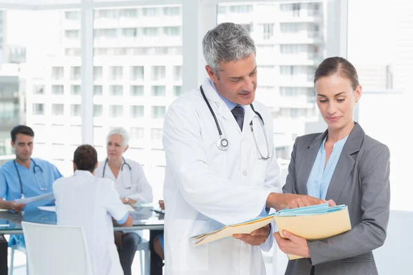 Male and female doctors working on reports — Stock Photo, Image