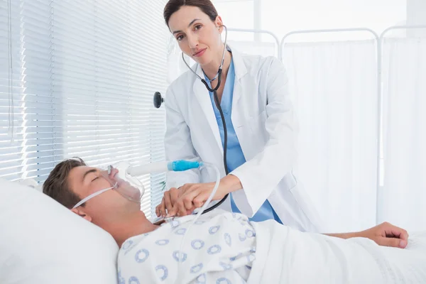 Sorrindo médico auscultando seus pacientes peito — Fotografia de Stock